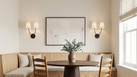 Two Cordelia Double Wall Sconces, in Aged Iron, shown in a banquette eat-in kitchen.