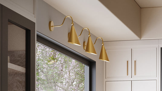 Three Faye adjustable wall light in aged brass above a large kitchen window in a modern home