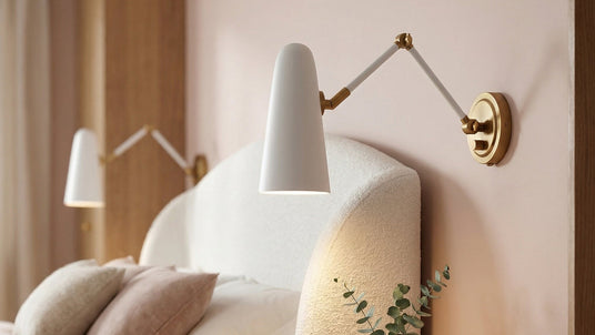 Two Roy Articulating Sconces in White shown as bedside lights against a blush colored wall