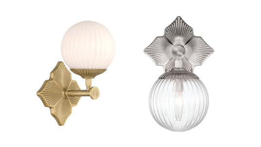 Three Victoria wall lights in polished nickel with opal glass in a bright primary bathroom with marble countertops.
