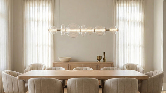 Elara LED 7 Light Linear Chandelier 56", Chrome and Clear Glass hung above a large contemporary dining table