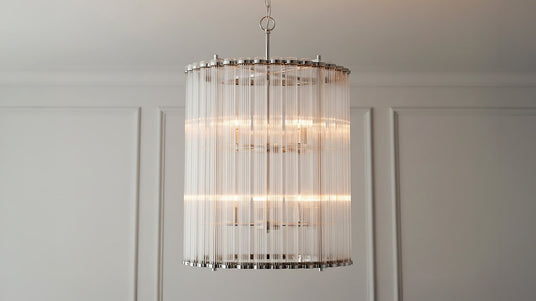 The Nori 8 Light Chandelier 22", Polished Nickel and Ribbed Glass finish shown in a transitional classic room with moldings and frost gray walls.