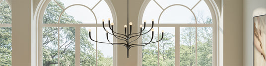 Anita 12 Light Chandelier 52" wide, Antique Iron finish, in a grand dining room with arched windows and modern art.