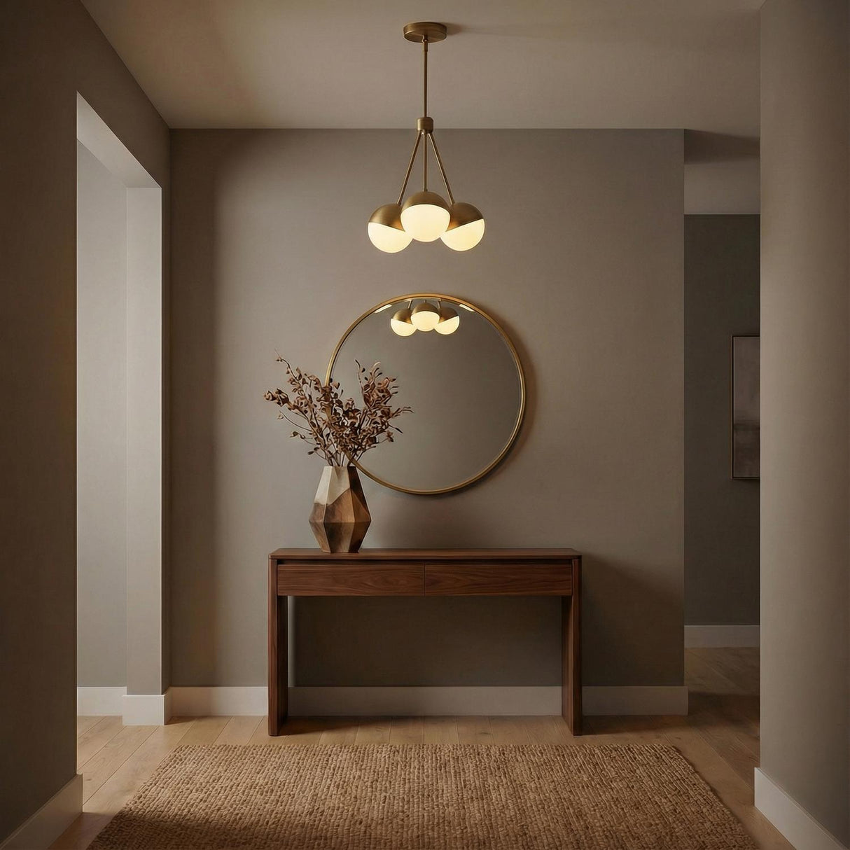 Powell 3 Light Chandelier 18", Aged Brass globe Chandelier in a Modern Entryway with a walnut console table and round mirror.