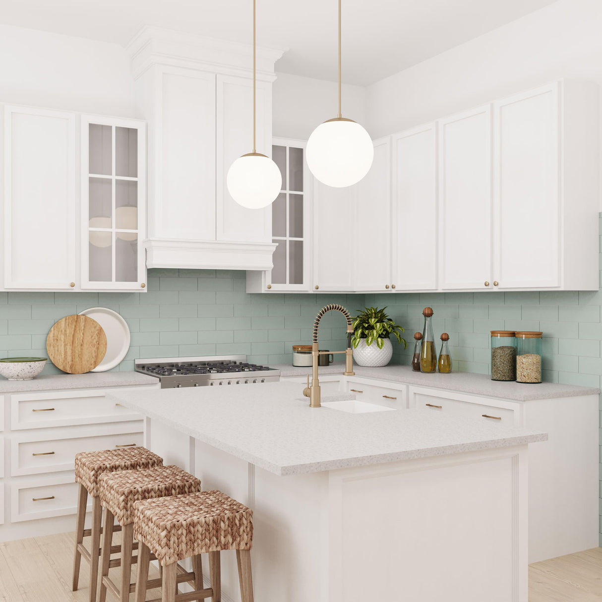 Two Castell 12" LED Pendant Lights in Aged Brass hung above a small kitchen island, in a bright white kitchen with ocean blue backsplash tiles