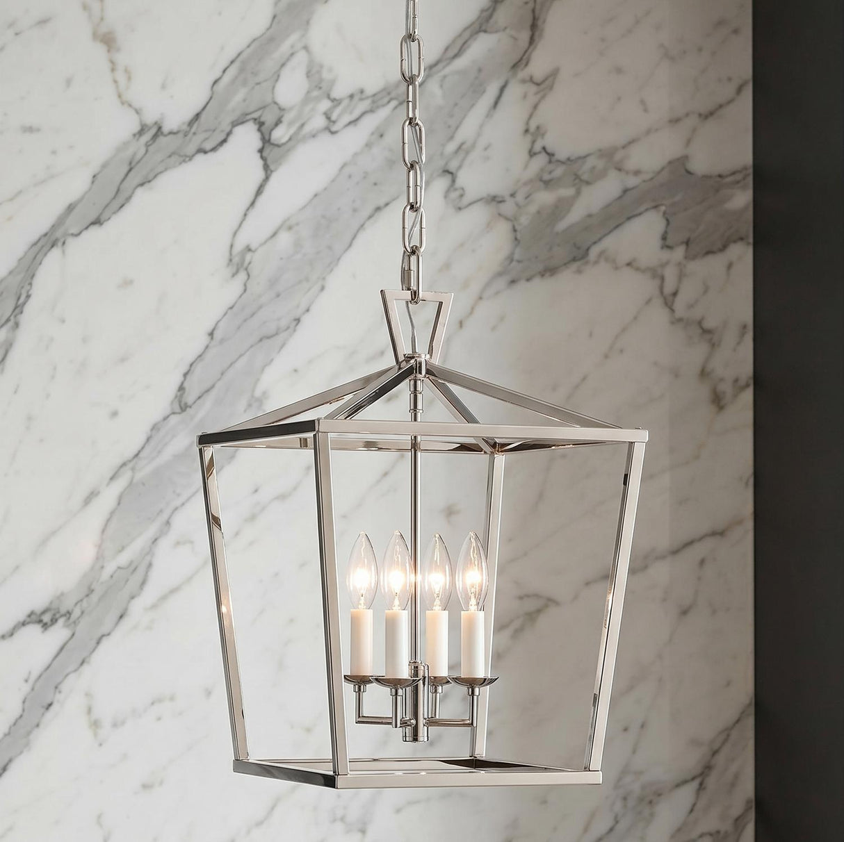A transitional foyer with the Anover Medium Lantern Pendant in polished nickel hanging over the entry against a white marble wall with grey veining.