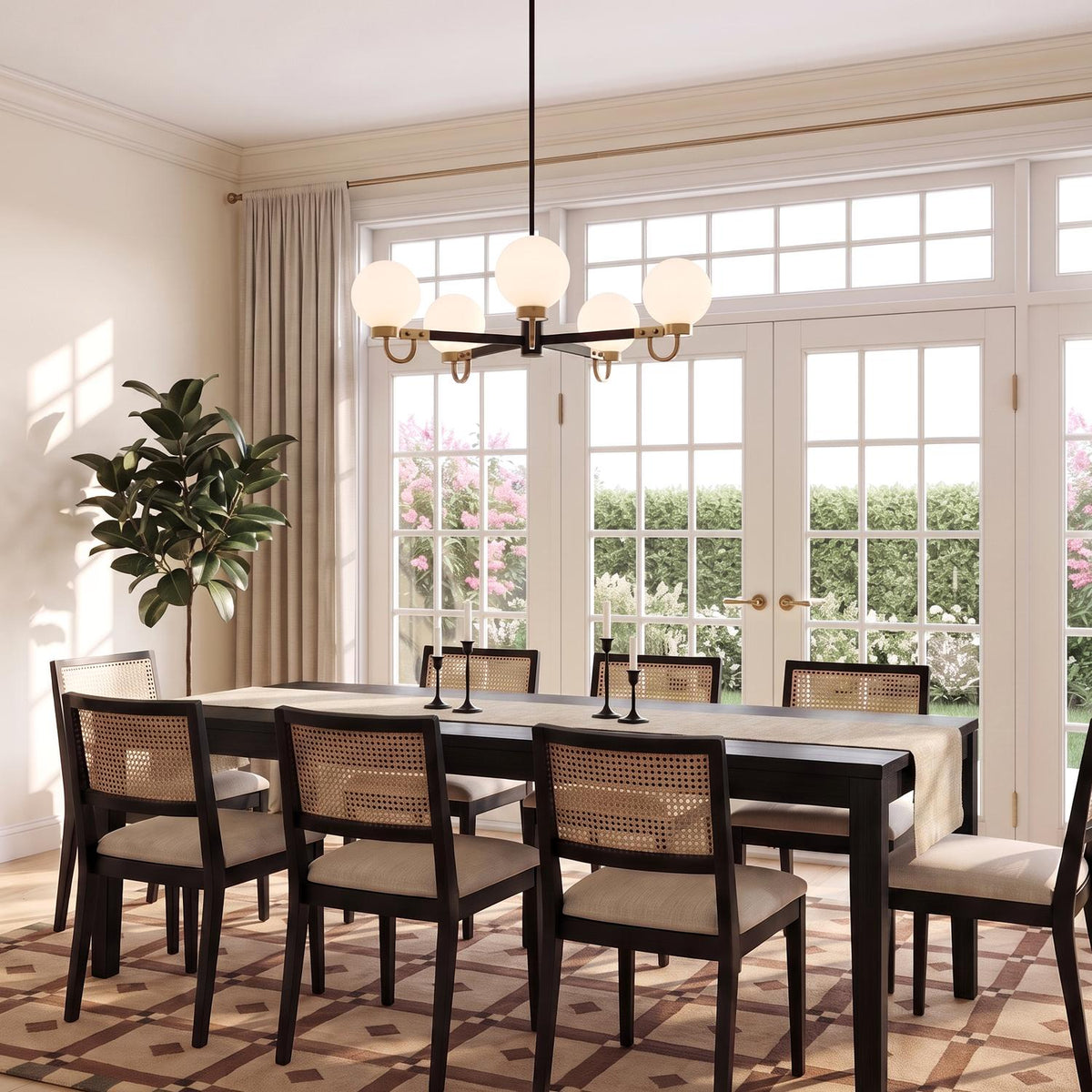 A transitional dining room with the Ryan 5 Light Chandelier 30", Matte Black and Aged Brass over a dark wood table and cane back dining chairs.