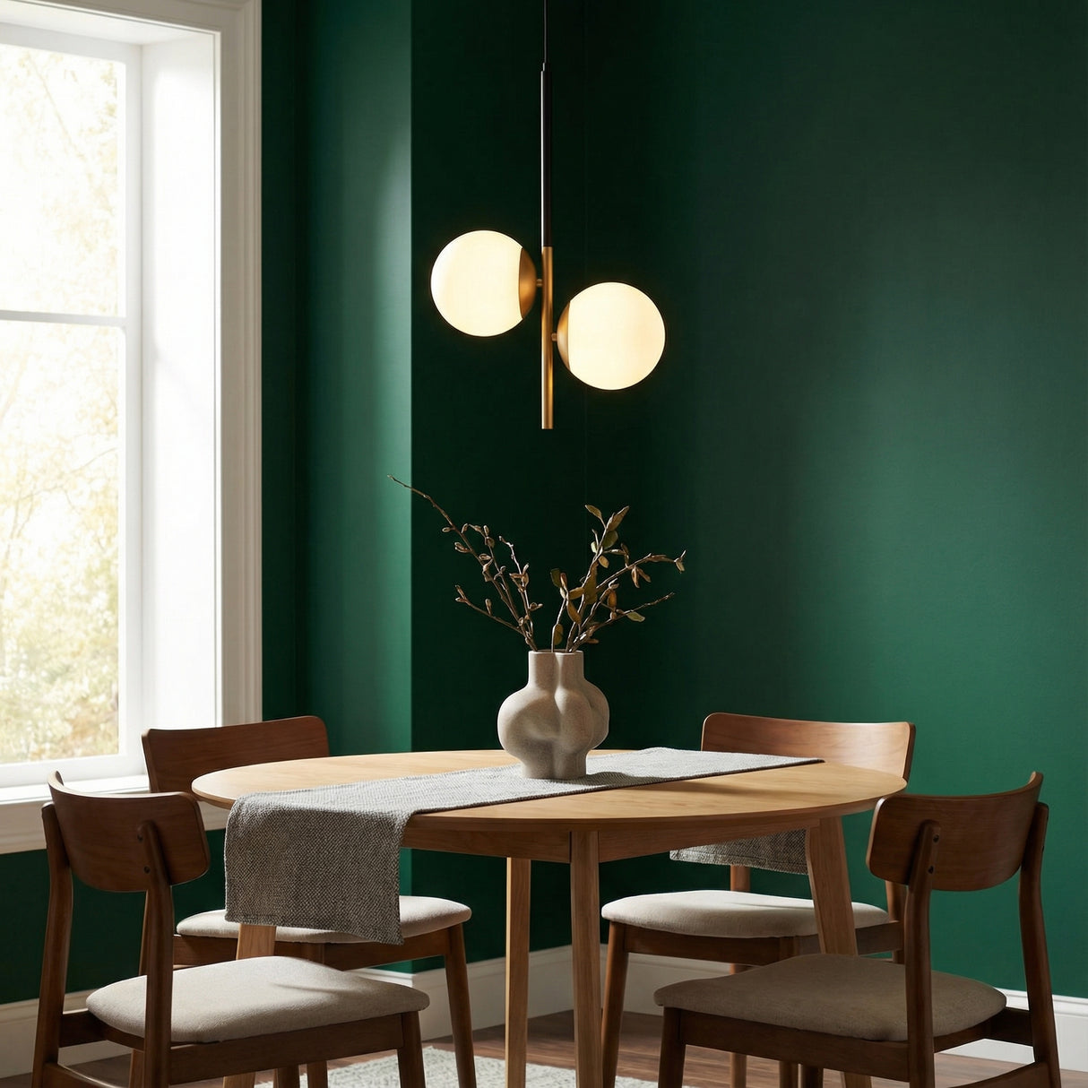 Matte Black and Brass globe pendant in a Modern Dining Room with dark green walls and a light wood dining table.