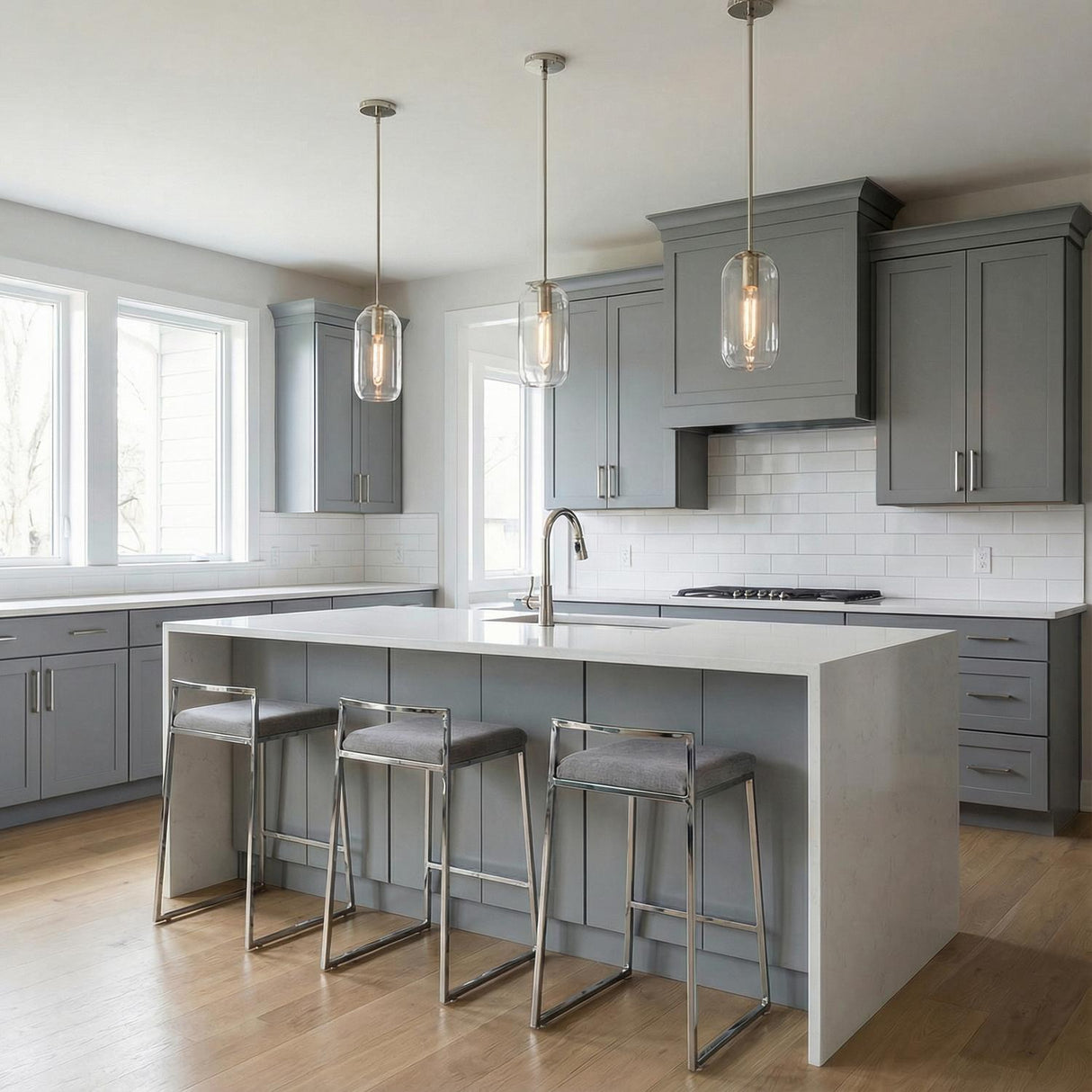 Clear glass Polished Nickel linear pendant in a Transitional Kitchen with a white marble island.