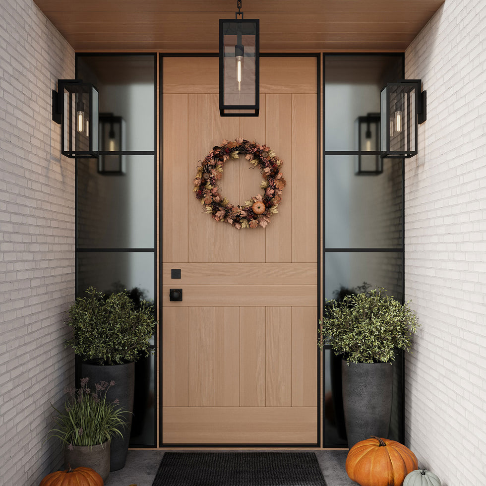 Decorative autumn wreath on a wooden door with modern Sam Outdoor wall lights and white brick walls.