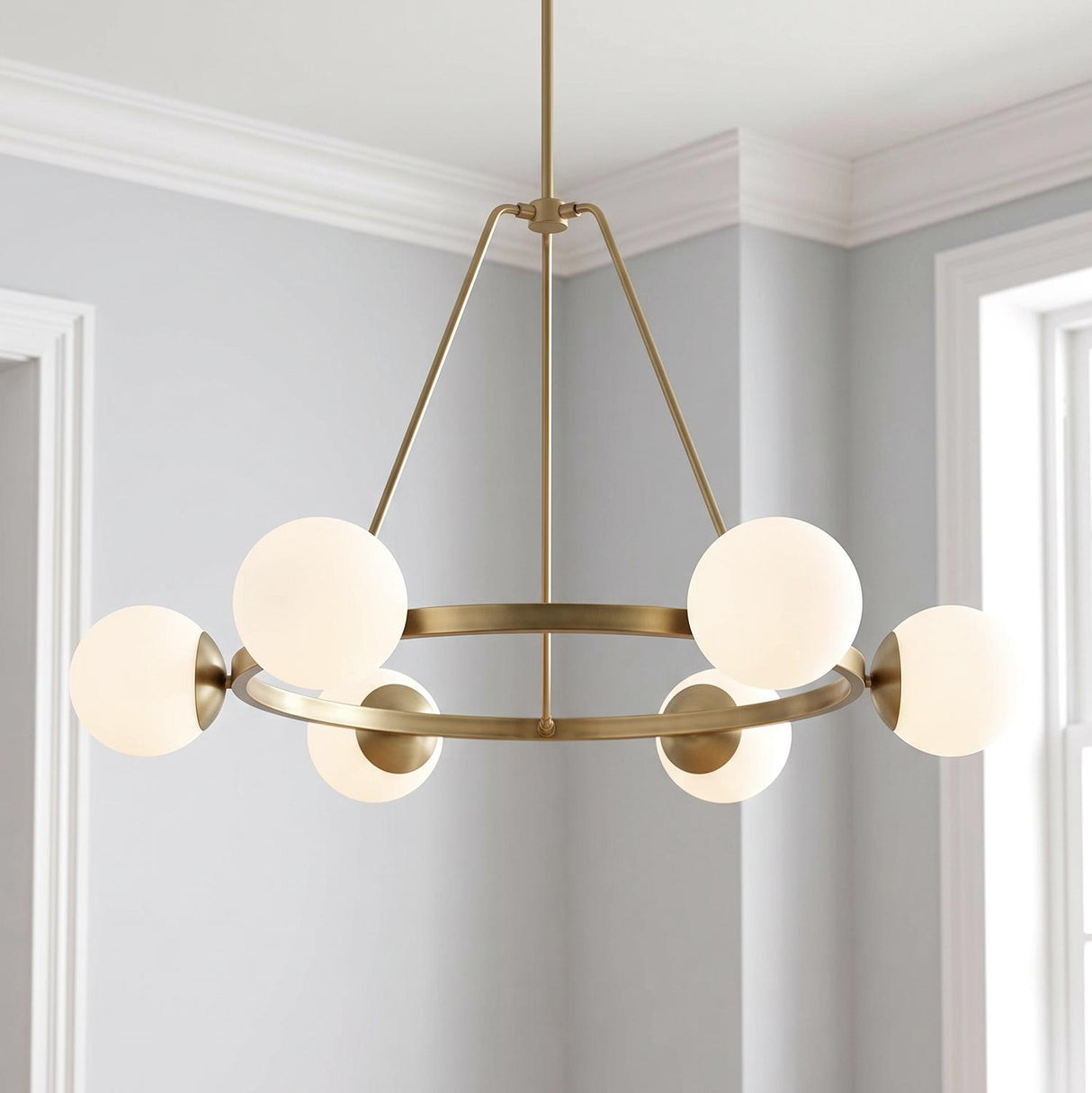A transitional dining room featuring the Castell 6 Globe Round Chandelier 36" in aged brass with frosted glass globes centered against white crown molding and light gray walls.