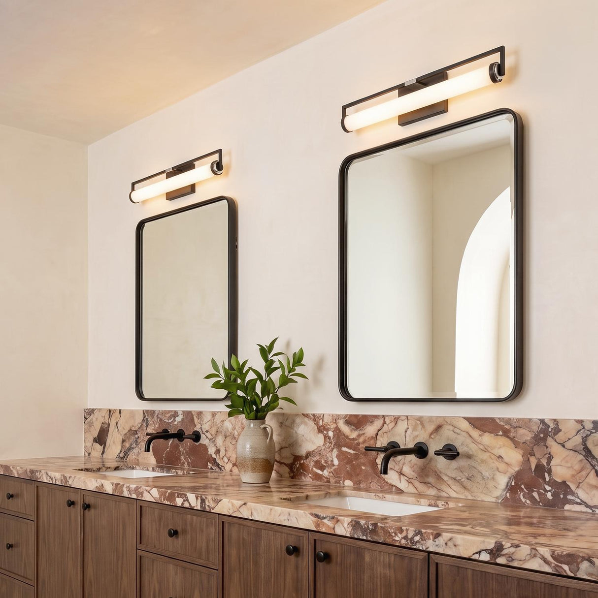 A modern bathroom with two Ian LED Vanity Lights in matte black and chrome finishes mounted over rectangular mirrors above a brown marble countertop.