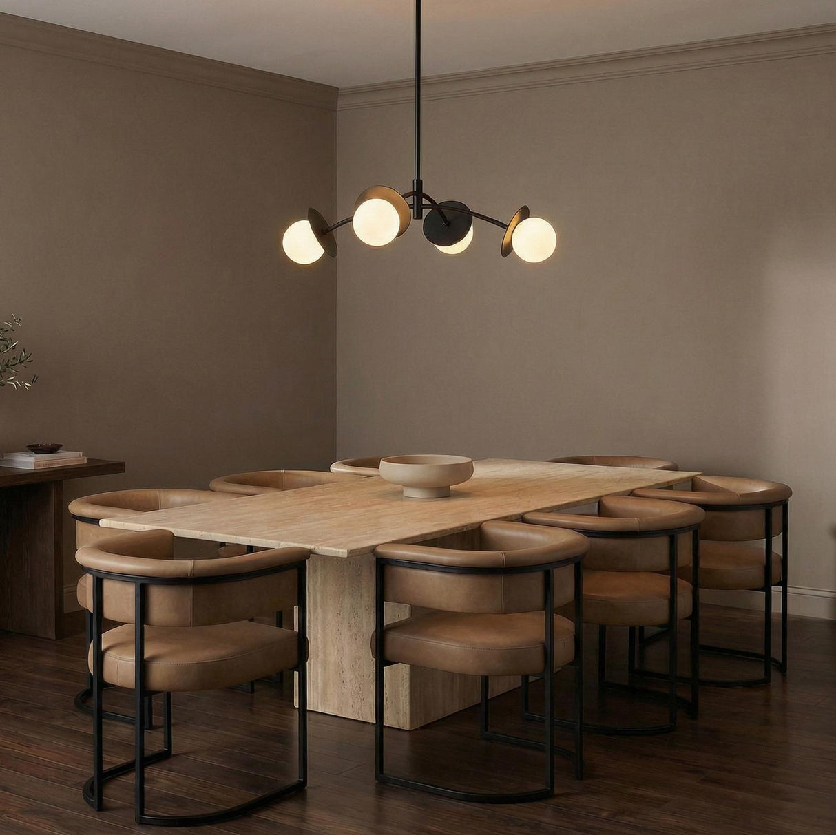 Matte Black globe design Chandelier in a Modern Dining Room with a travertine stone table and tan leather chairs.