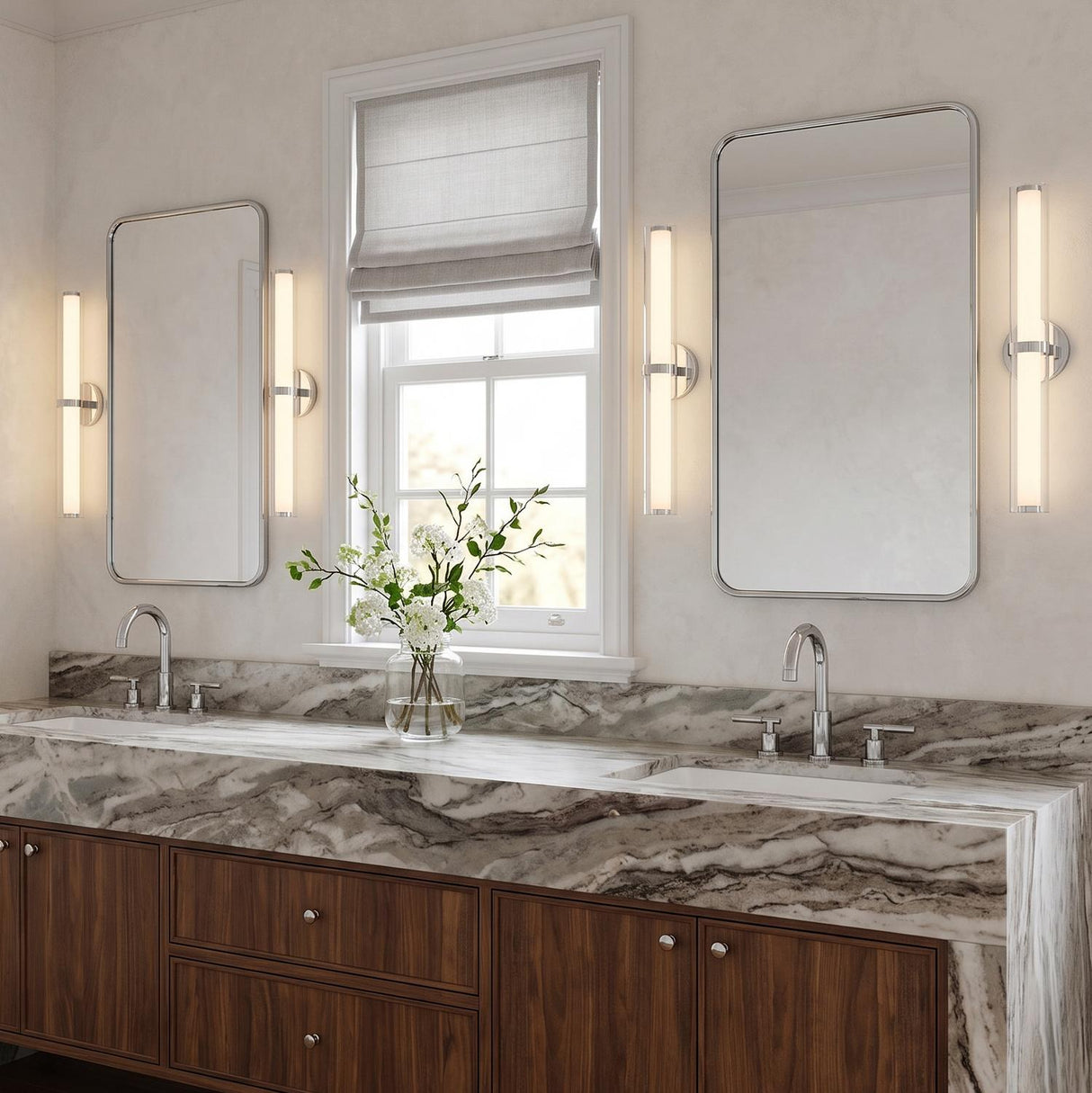 A transitional bathroom with four polished chrome Ellie LED Vanity Lights flanking two mirrors above a veined marble waterfall countertop and dark walnut cabinetry.