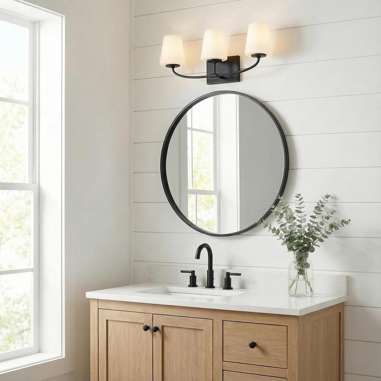 3 Light Vanity, Matte Black linear Vanity in a Modern Farmhouse Bathroom with a natural wood vanity and round mirror.