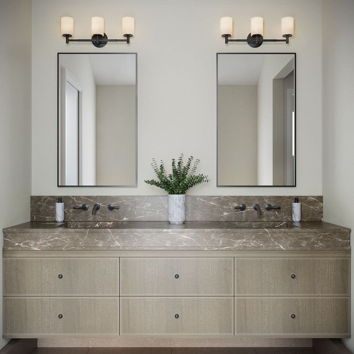 A pair of Becca 3 Light Vanity lights in matte black are shown above a double vanity with modern black thin framed mirrors and natural stone countertop