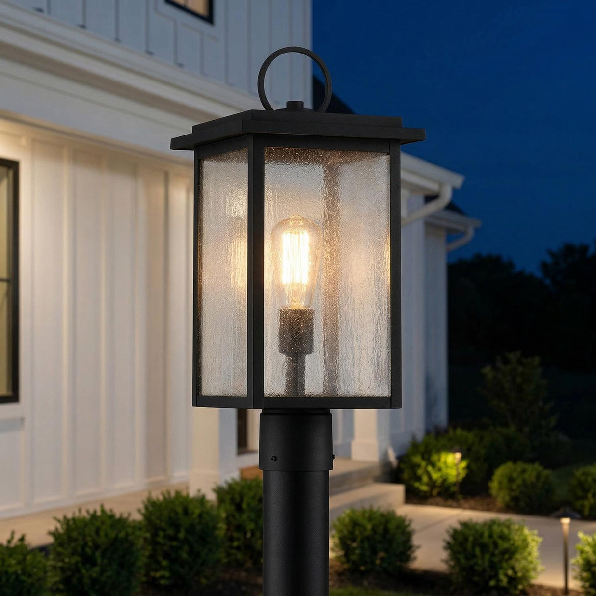 Paterson Outdoor Post Light Matte Black geometric seeded glass Outdoor Post in a Modern Farmhouse Outdoor with white board and batten siding.