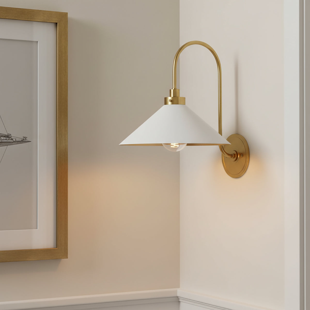 Alma wall sconce with white shade on a neutral wall next to a framed picture.