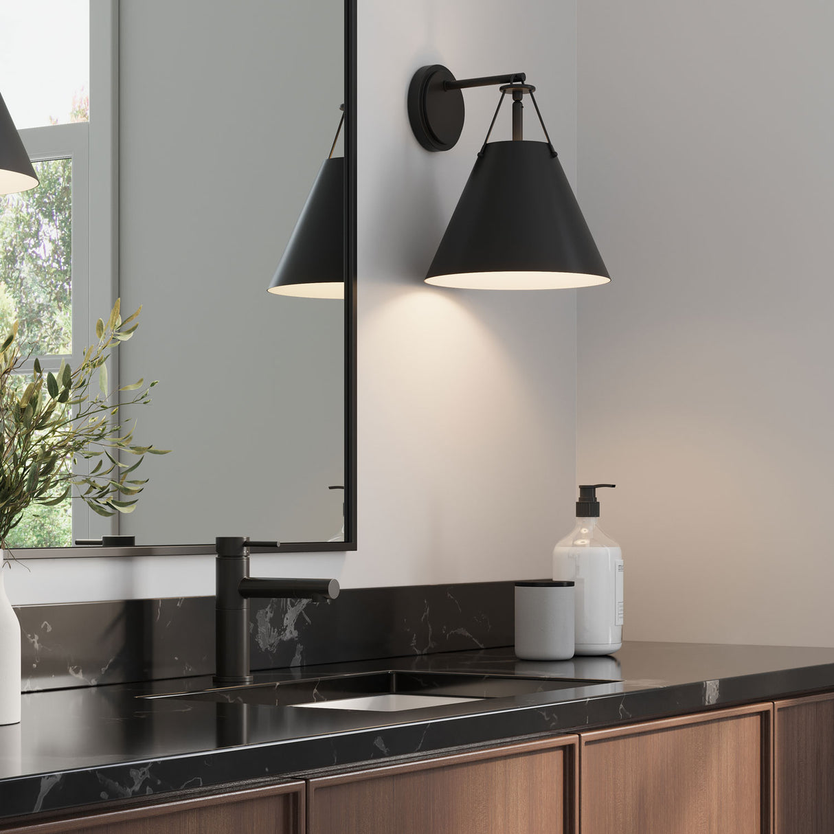 Bowie wall sconce in black, shown in a modern bathroom with black marble counters and a walnut vanity, hung next to the mirror.