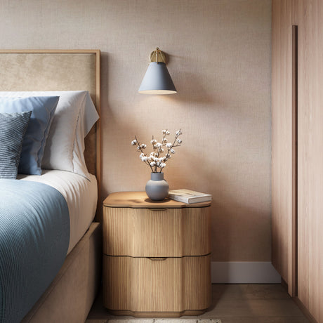 Bowie wall sconce in French Blue and Brass as a bedside light, in a modern bedroom with light wood and luxe cream and blue bedding.