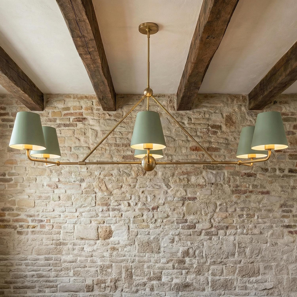 Banks 6 Light Linear Chandelier 46", Sage Green and Brass linear Chandelier in a Modern Farmhouse Dining Room with a stone wall.