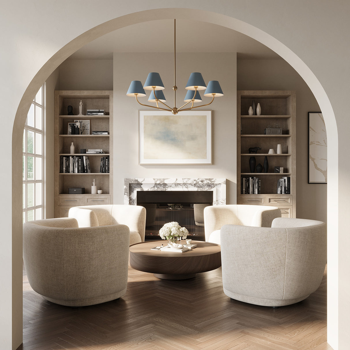 Banks French Blue Chandelier, with brass accents, 40" wide and with six conical shades, is hung in a contemporary living room with an arched entry, seating area with cream swivel chairs, and herringbone wood floors.