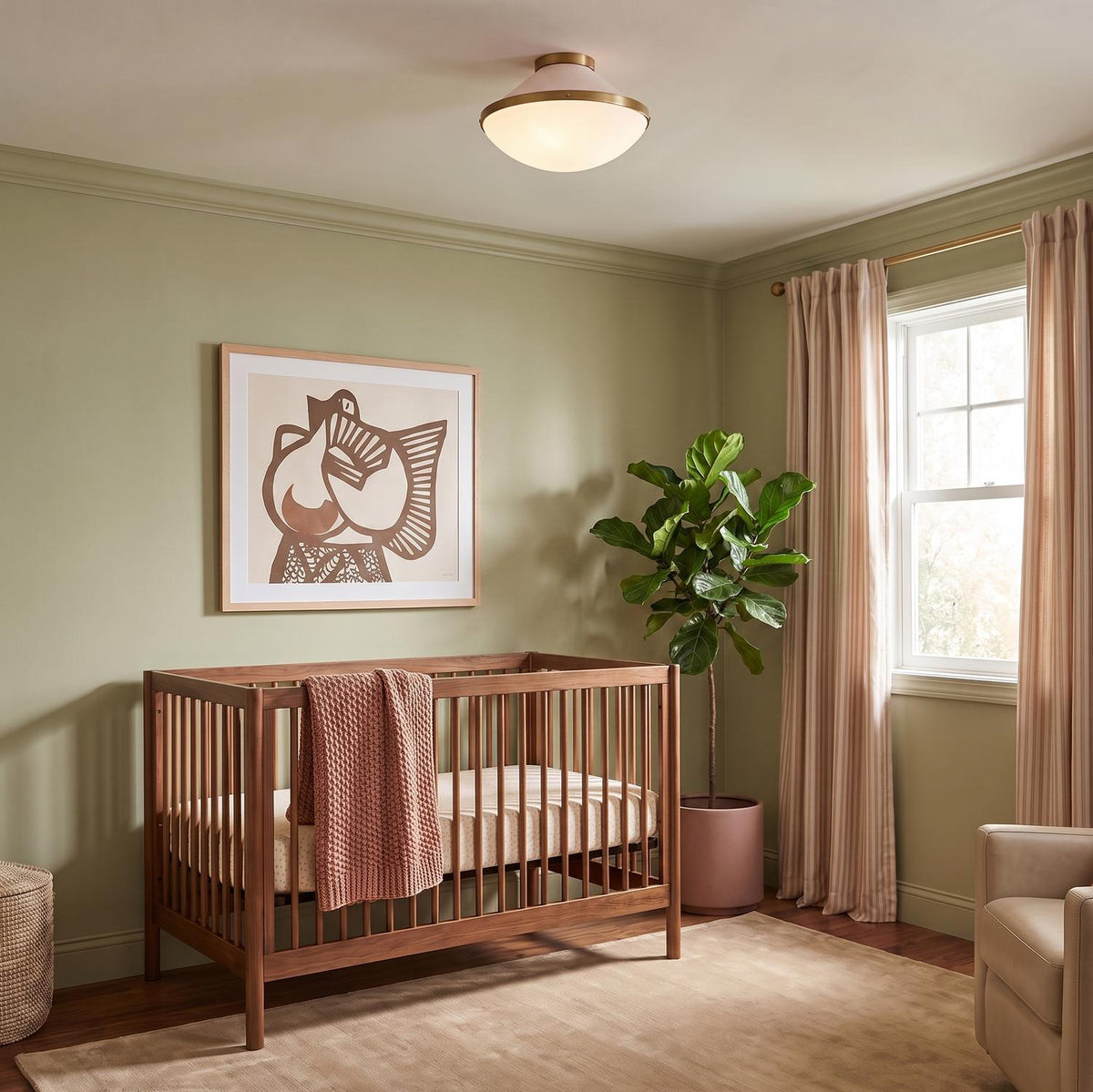 A mid-century modern bedroom with the Blair Flush Mount 16", Rose Quartz and Brass on the ceiling above a walnut wood crib and olive green walls.
