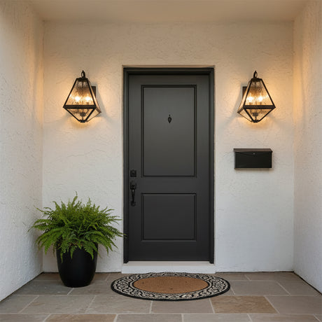 Emmett Outdoor Wall Light, Medium 17" Black Charcoal - Two black geometric wall lights illuminate a black front door with a planter and doormat.