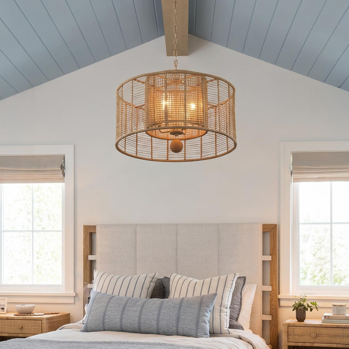 A coastal bedroom with the Sellah 4 Light Pendant 25", Jute and Satin Sand hanging along the ceiling center above a beige headboard and vaulted blue shiplap ceiling.