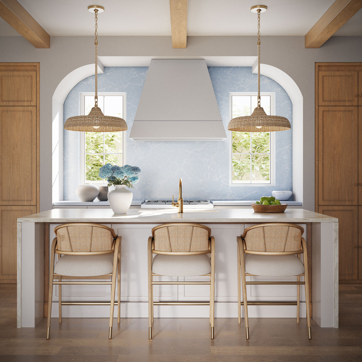 Coastal transitional kitchen with two Sarina woven 20" pendant lights hung above a kitchen island, with white oak cabinets, white stone, and a blue marble backsplash.