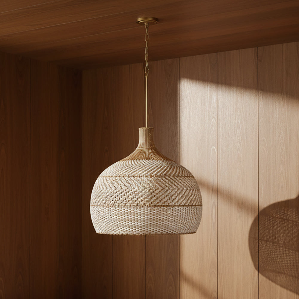 Sienna Extra Large Pendant 26, Rattan and Soft Brass - A woven pendant light hanging in a wood-paneled room