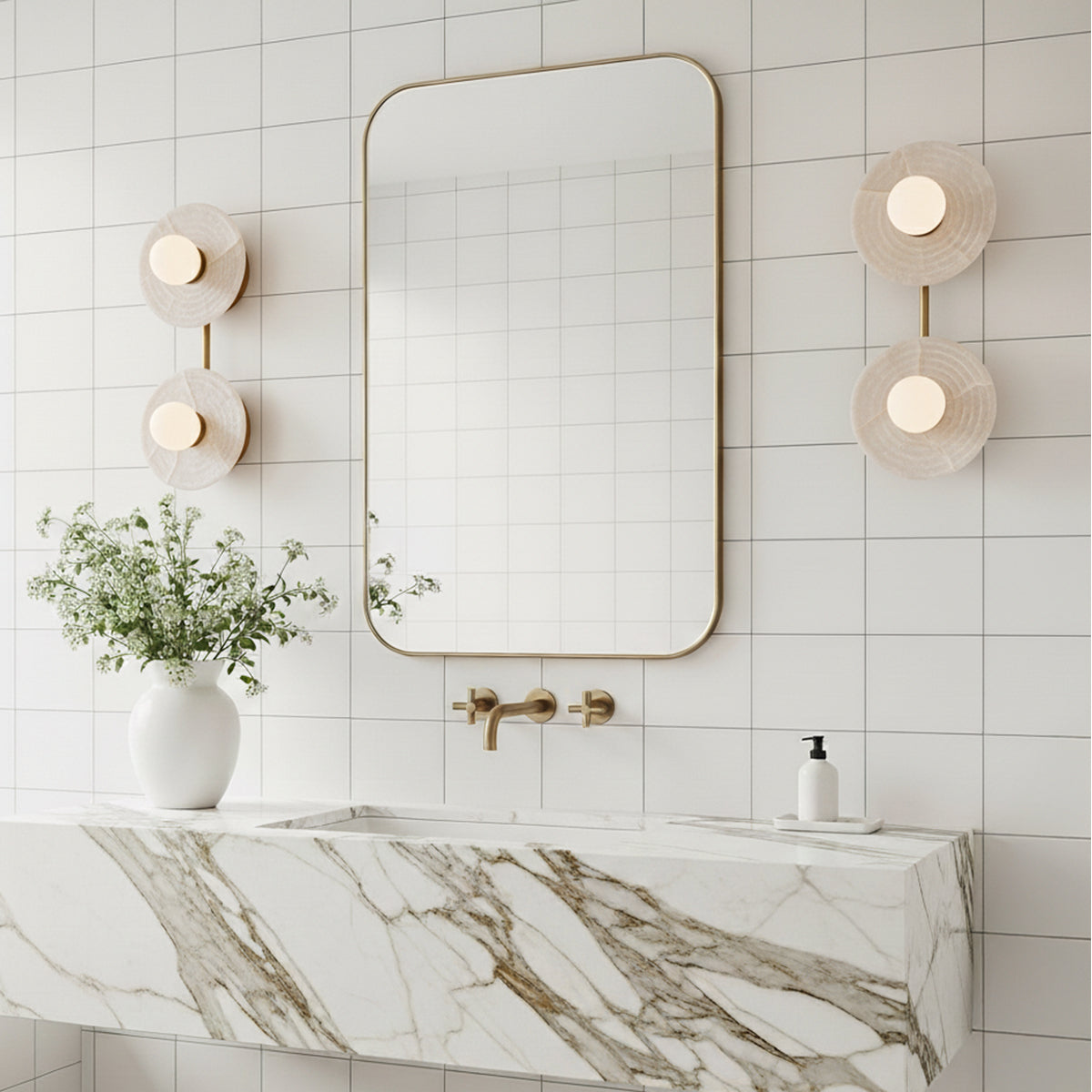 Bathroom with marble countertop, mirror, and two Bren wall lights in vintage brass with Alabaster
