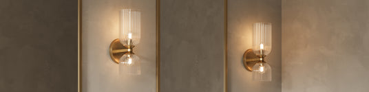 Two Elle Wall Sconce, in Brushed Brass and Clear Fluted Glass, shown in a bathroom with venetian plaster walls and gold framed mirrors