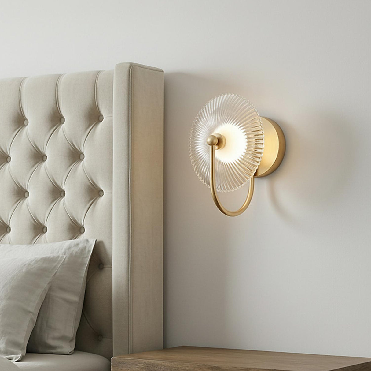 Ivan LED Curved Arm Wall Sconce, Brushed Brass geometric Wall Sconce in a Transitional Bedroom with a tufted upholstered headboard.