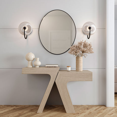 Two 11.25" tall Ivan modern wall sconces with black finish and reeded glass are shown in an entryway above a sculptural console table.