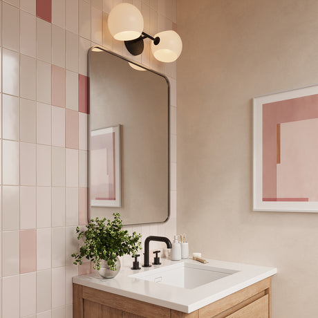 Modern powder room with pops of pink and blush shown with the Flynn 2 Light wall sconce above the mirror in black.