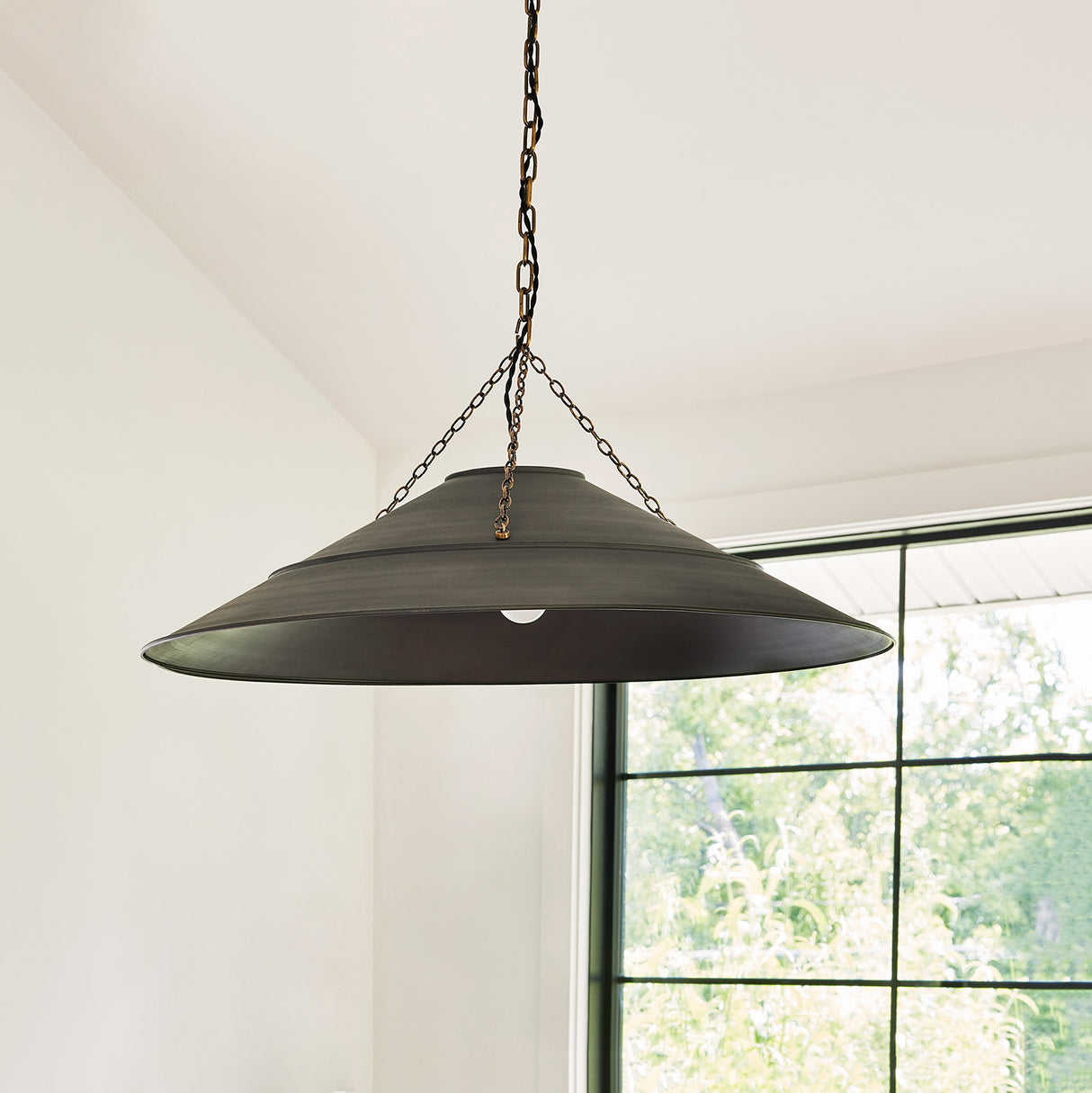 Zane Extra Large Graphite pendant with patina brass details in a living room. Photo courtesy of Mark Weinberg