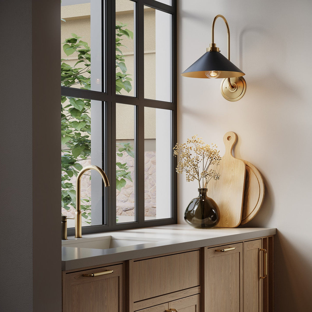 Alma gooseneck metal wall sconce in black with aged brass details is shown in a modern butlers pantry.