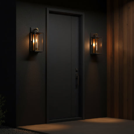 Two Orin Outdoor Small Wall Lights, Bronze with Vintage Brass Accents, shown at night on a dark grey modern facade with wood accent wall.