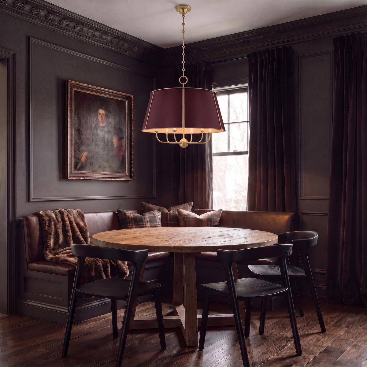A transitional dining room features the Avery 6 Light Extra Large Pendant 28", Bordeaux with Aged Brass hanging over a round wood table and leather banquette.