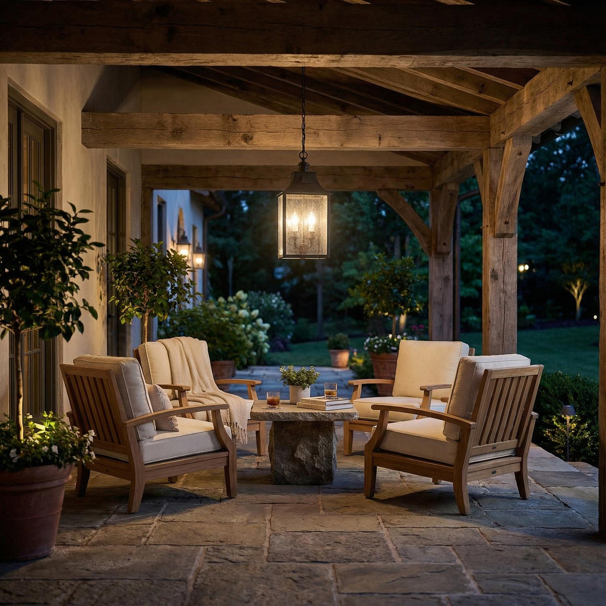 Bedford Antique Black Iron geometric Outdoor Hanging in a Farmhouse Outdoor with wooden armchairs and a stone table.