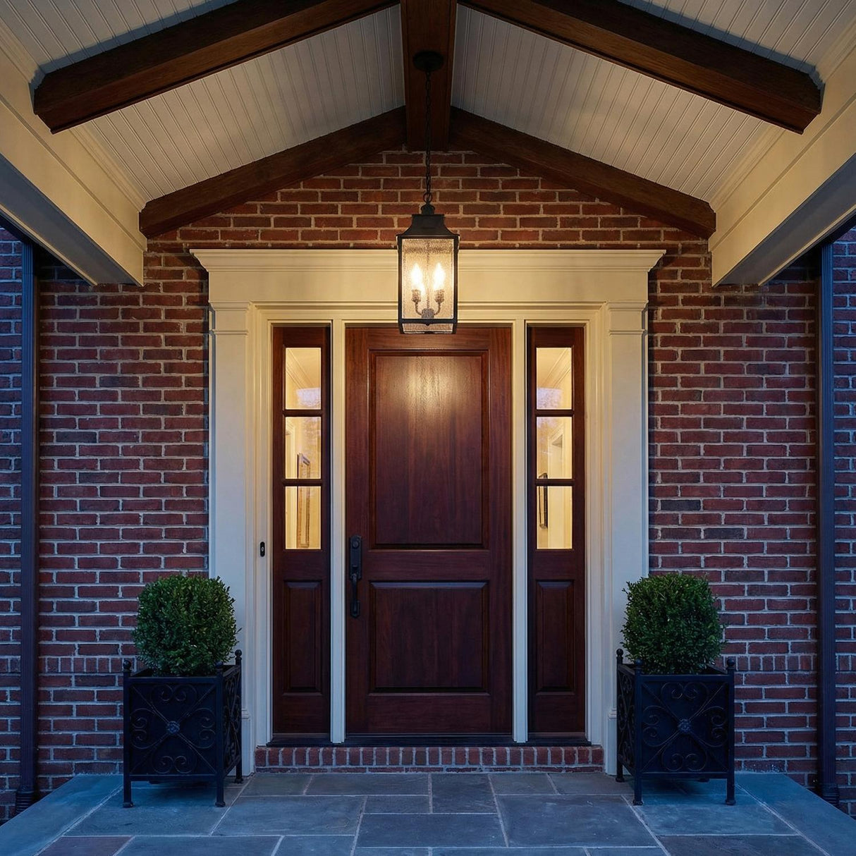 Bedford Outdoor Hanging Light, Antique Black Iron geometric Outdoor Hanging in a Colonial Outdoor with a dark wood door and brick walls.