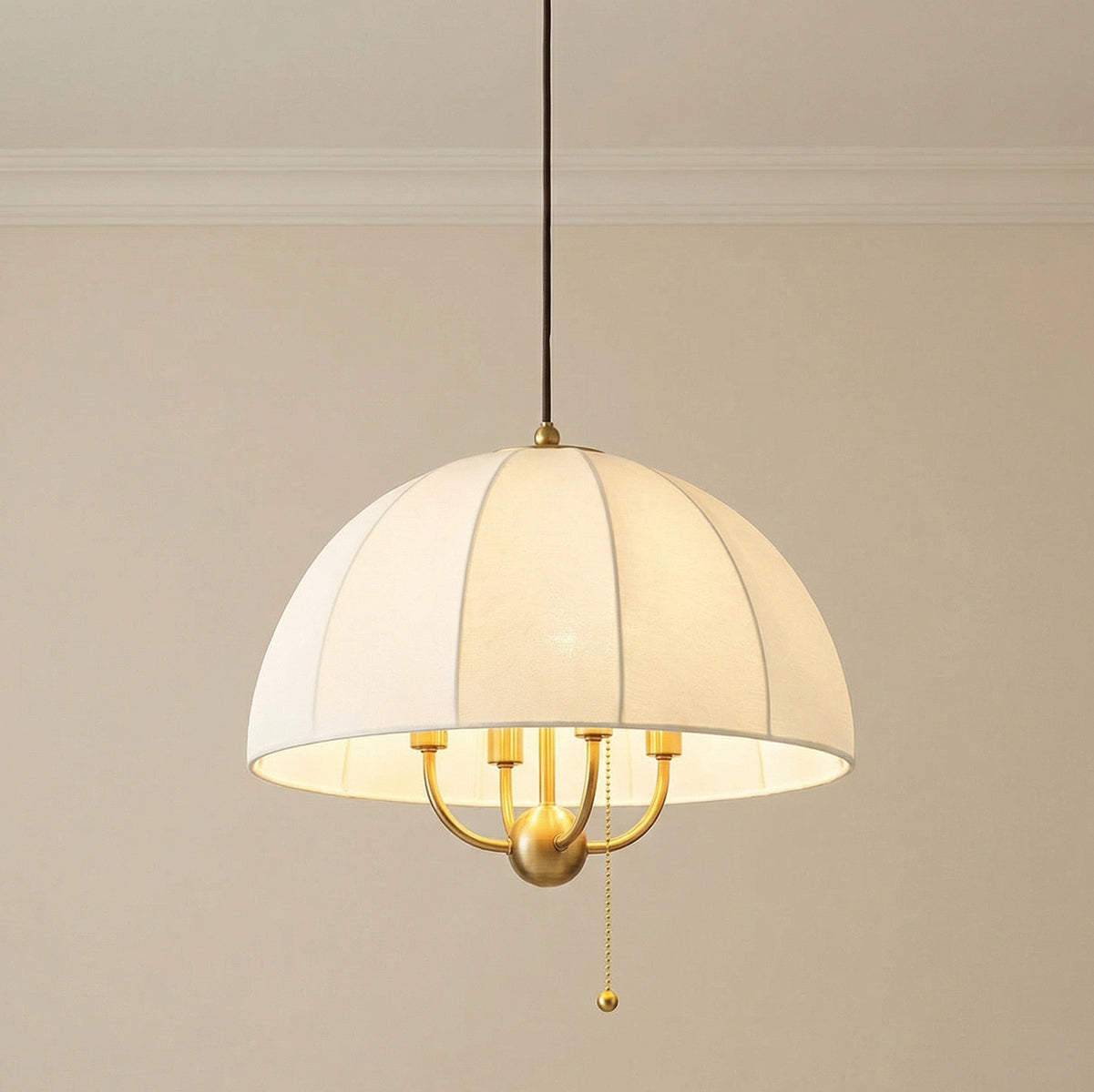 Brushed Brass with Cream Fabric Shade linear pendant in a Transitional Living Room with elegant crown molding.