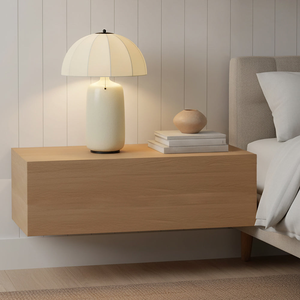 Trudy Table Lamp, Cream with Black Accents - Cream lamp with a fluted shade on a wood nightstand next to a bed