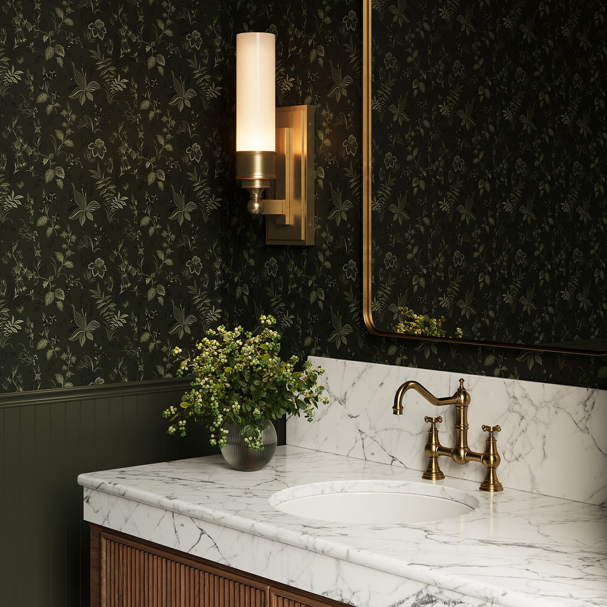 Connor 1 Light Wall Sconce in Aged Brass in a powder room with green modern floral wallpaper.