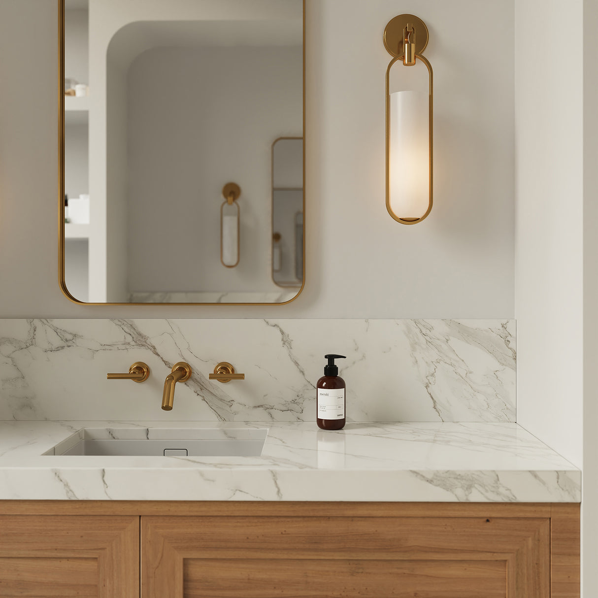 Micah LED Wall Sconce is 22" tall and shown in a modern bathroom next to the brass mirror.