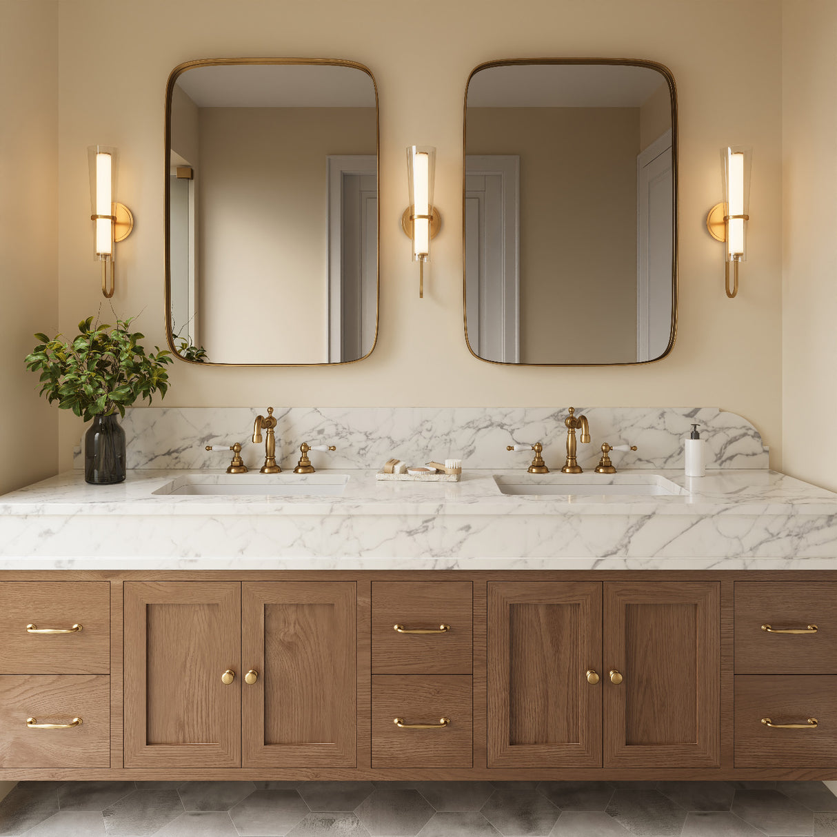 Three Claire LED Wall Sconces in Aged Brass shown in a primary bathroom above a double vanity.