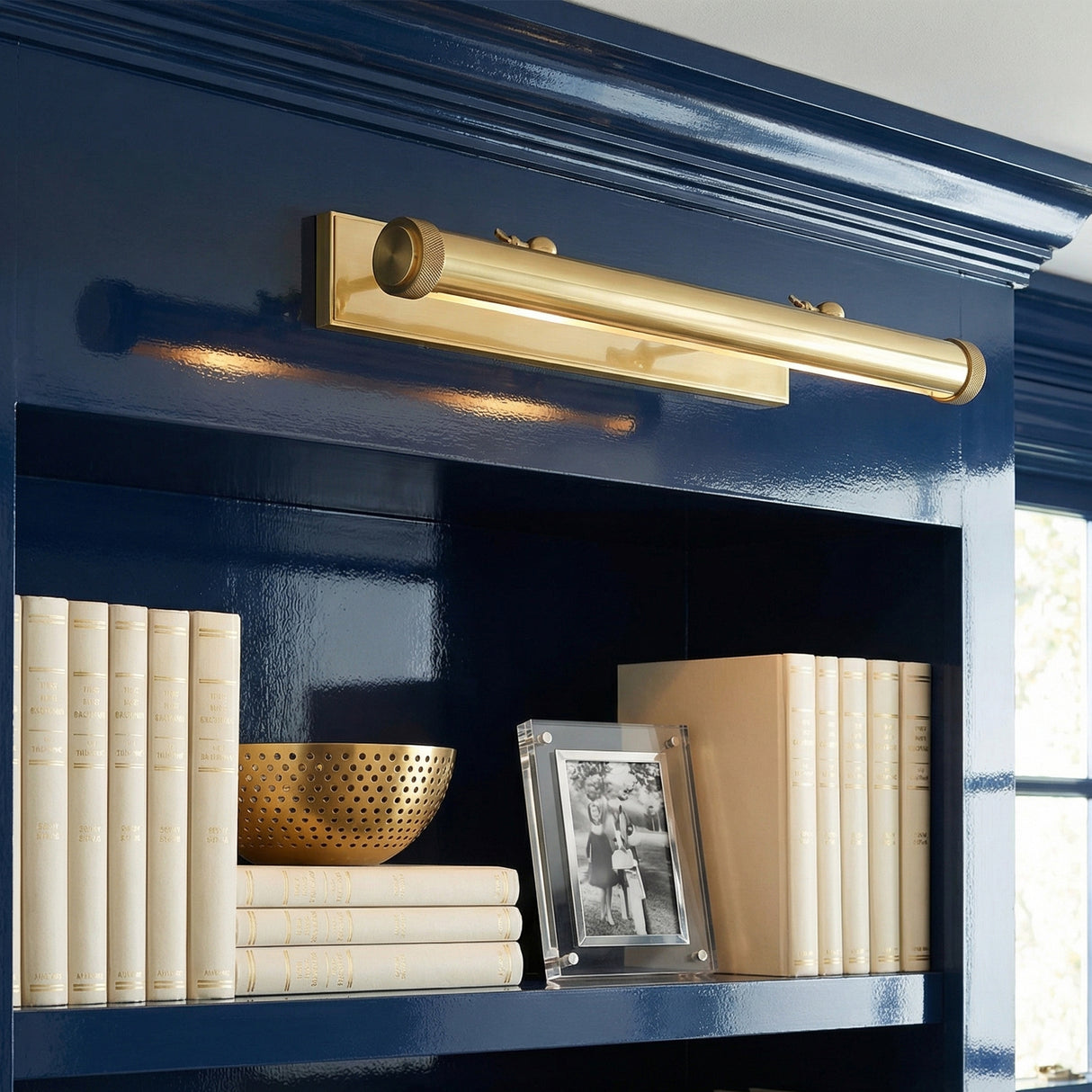 Graham Extra Large Picture Light, Brass linear Picture Light in a Transitional Living Room with navy blue built-in shelves.