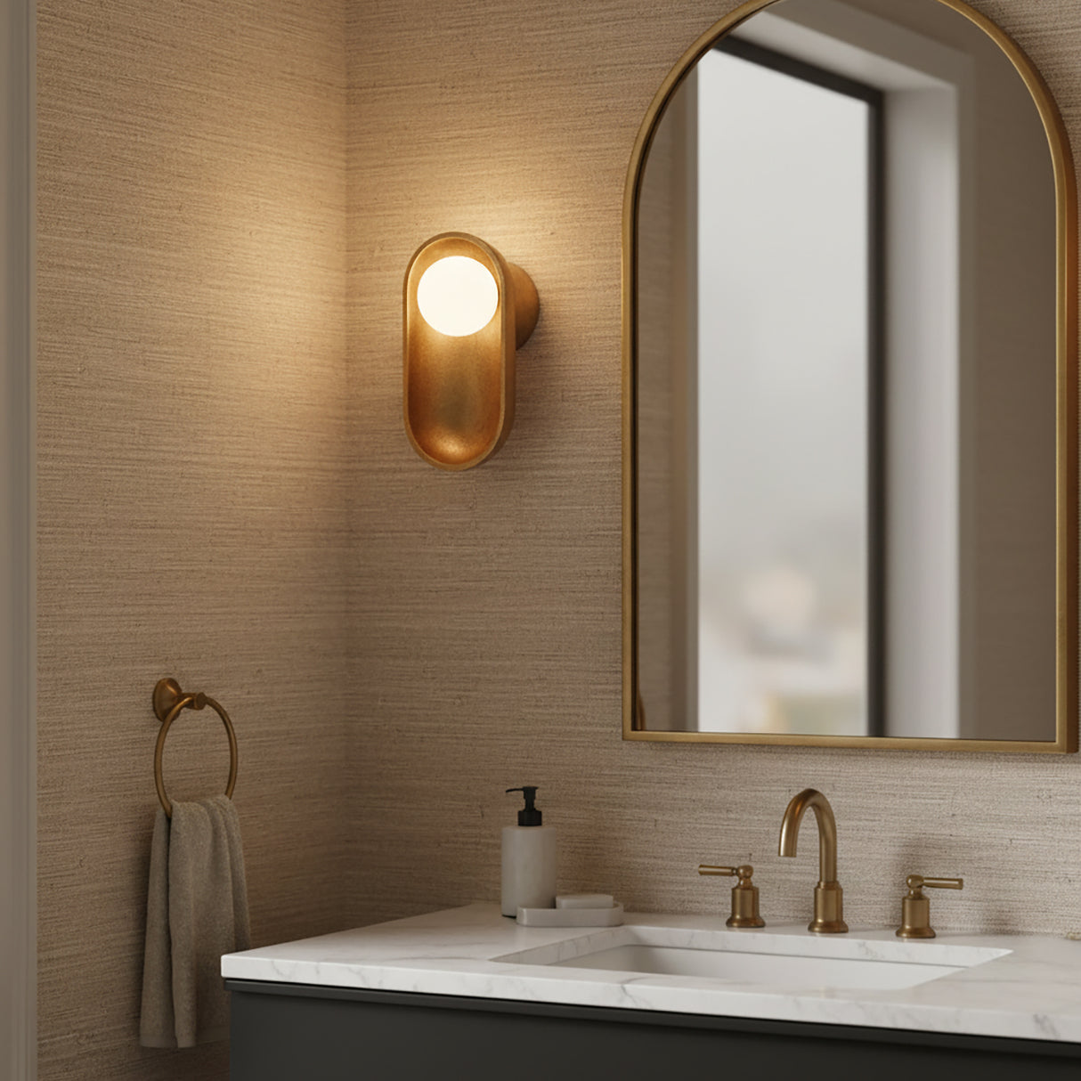 Jasper Wall Sconce 11, Textured Aged Brass shown in a modern powder room with textured beige walls