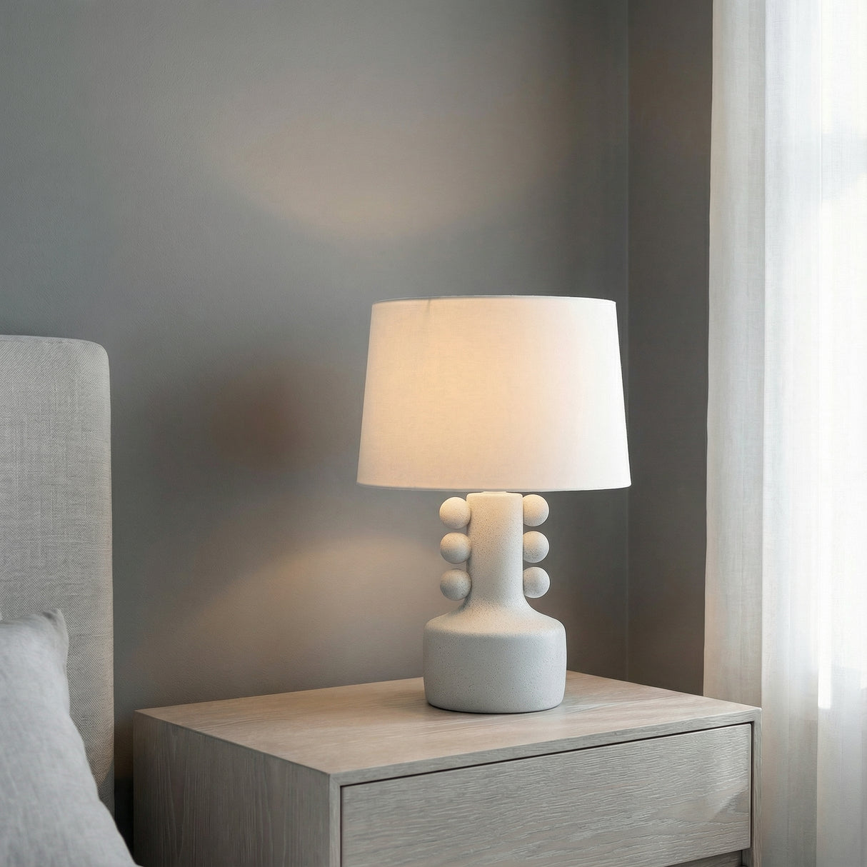 Mia Ceramic Table Lamp, Speckled White beaded Table Lamp in a Modern Bedroom with a light wood nightstand.